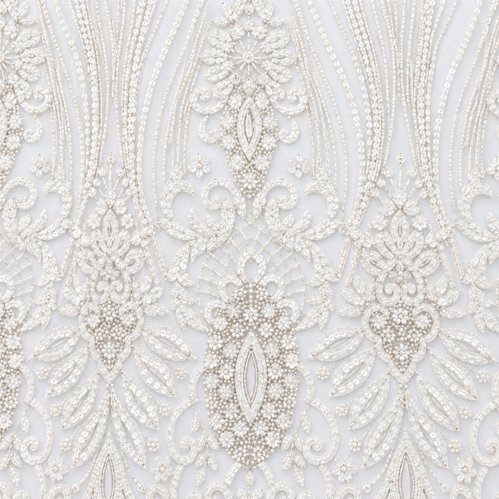 Close-up of white bridal tulle with silver plume-shaped beadwork and floral medallions