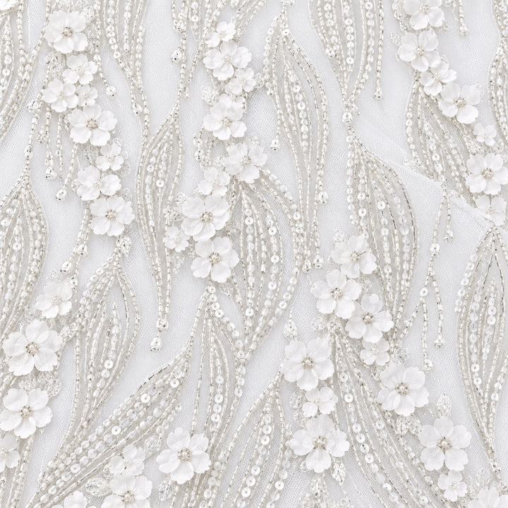 Close-up of white bridal tulle with sweeping silver beaded leaves and dimensional blossoms