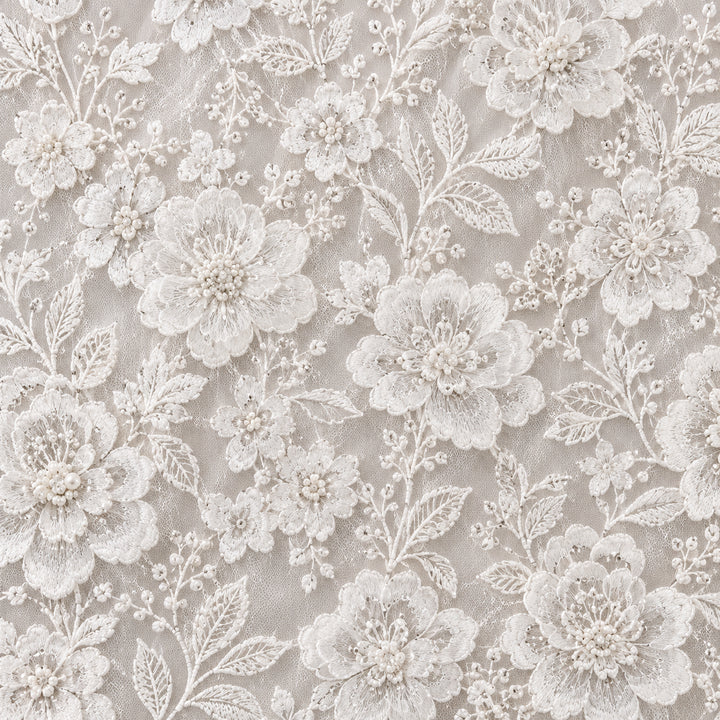 Close-up of white sheer tulle with all-over rose floral embroidery and delicate leafy vines